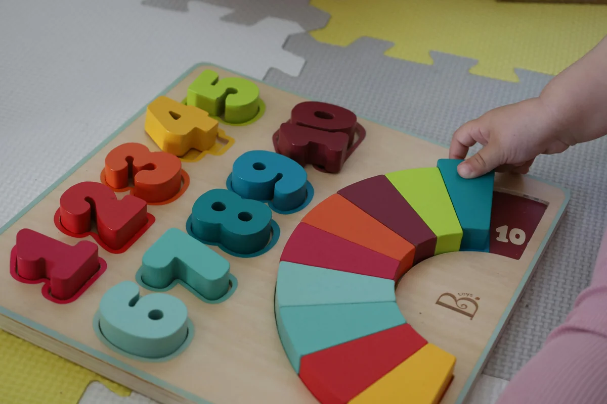 a child is playing with a wooden toy - child development