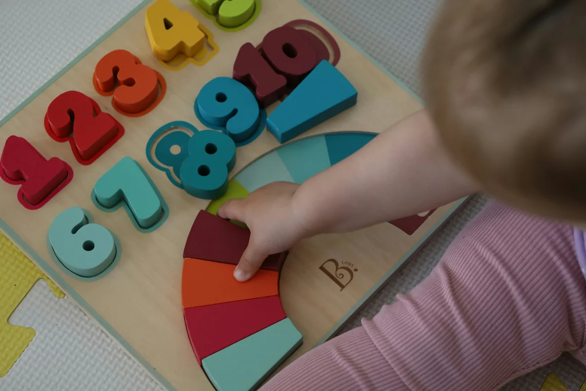 a child is playing with a wooden toy - child development