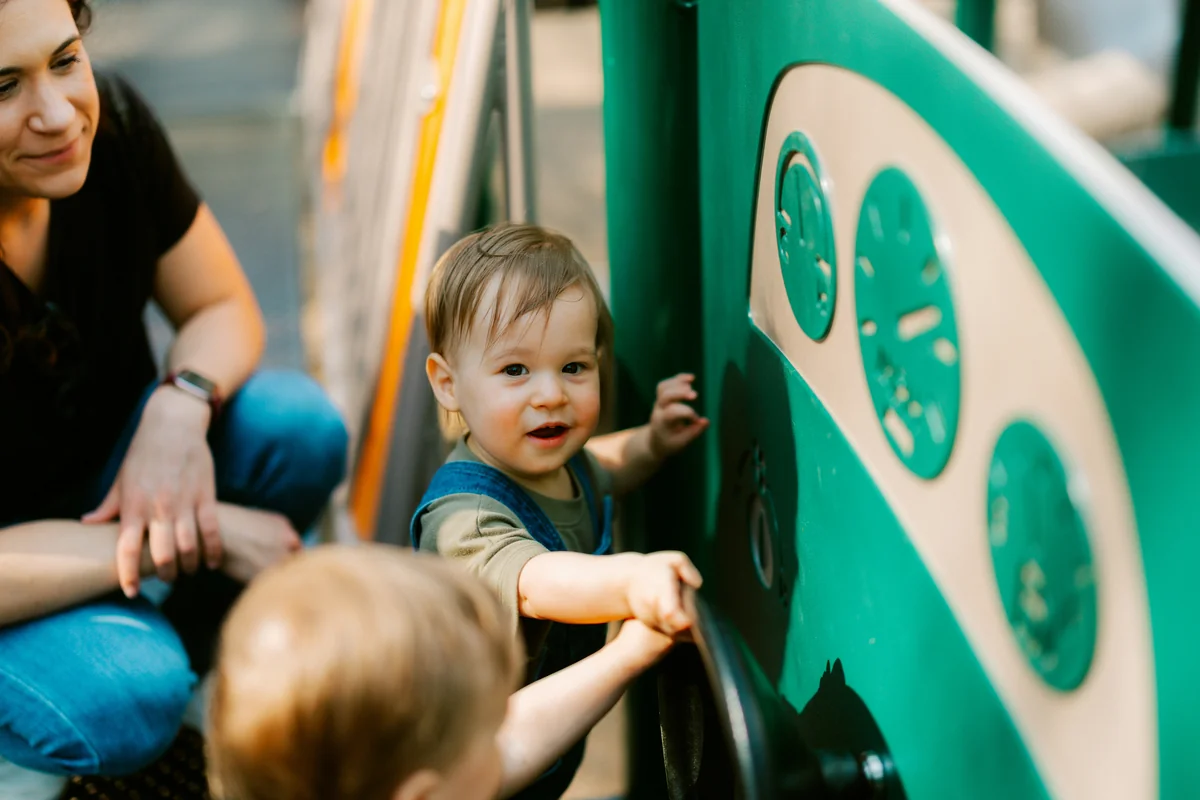 A woman and two babies at a playground - child development