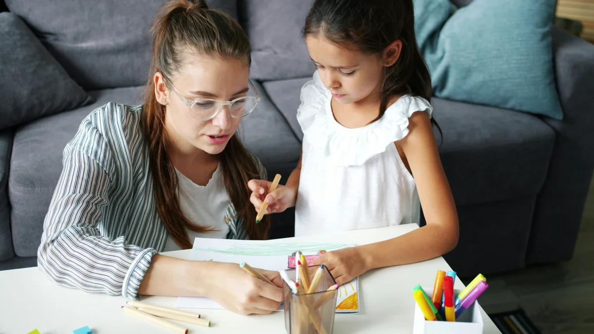 Happy family daughter and mother drawing picture at table in apartment, joyful kid is smiling enjoying hobby and mother's help. People and lifestyle concept. - home schooling strategies
