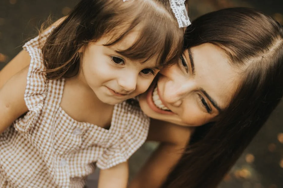 A joyful moment with a young mother and daughter smiling together outdoors. - parentchild communication