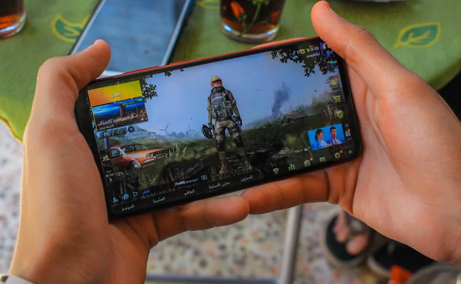 From above crop anonymous male playing captivating video game on contemporary mobile phone near table on terrace - pubg mobile gameplay