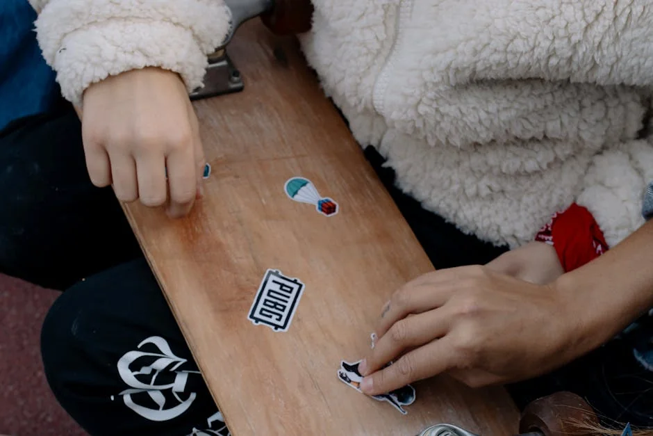 Close-up of hands placing stickers on a skateboard, showcasing creativity and personal style. - pubg mobile gameplay
