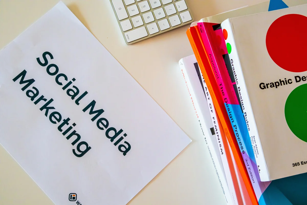 backlink seo: 5 Best Secrets That Actually Work 6 Home desk with design books and a paper with the words Social Media Marketing on it